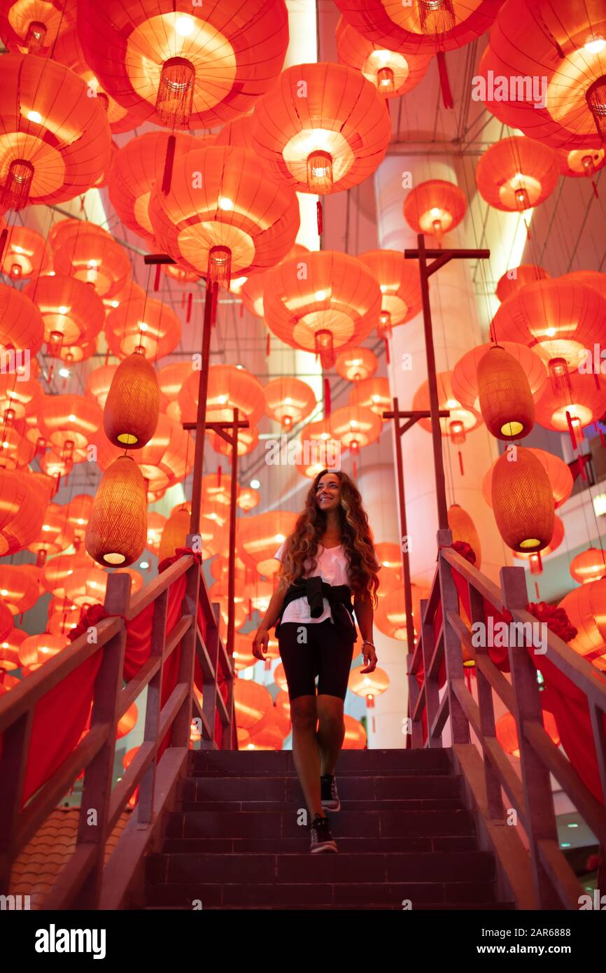 Happy admiring woman enjoying traditional red lanterns decorated for