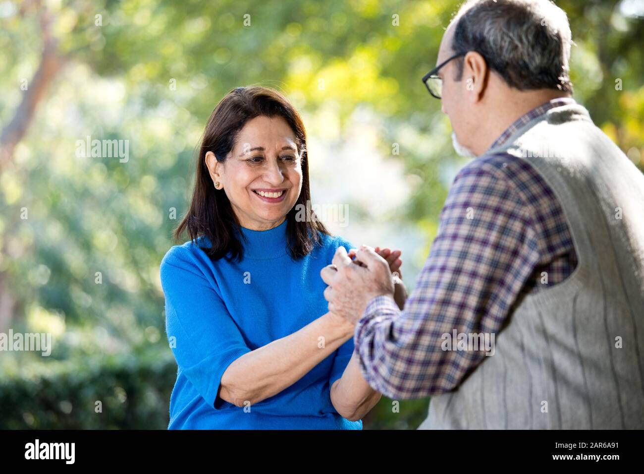 Happy senior couple holding hands at park Stock Photo - Alamy