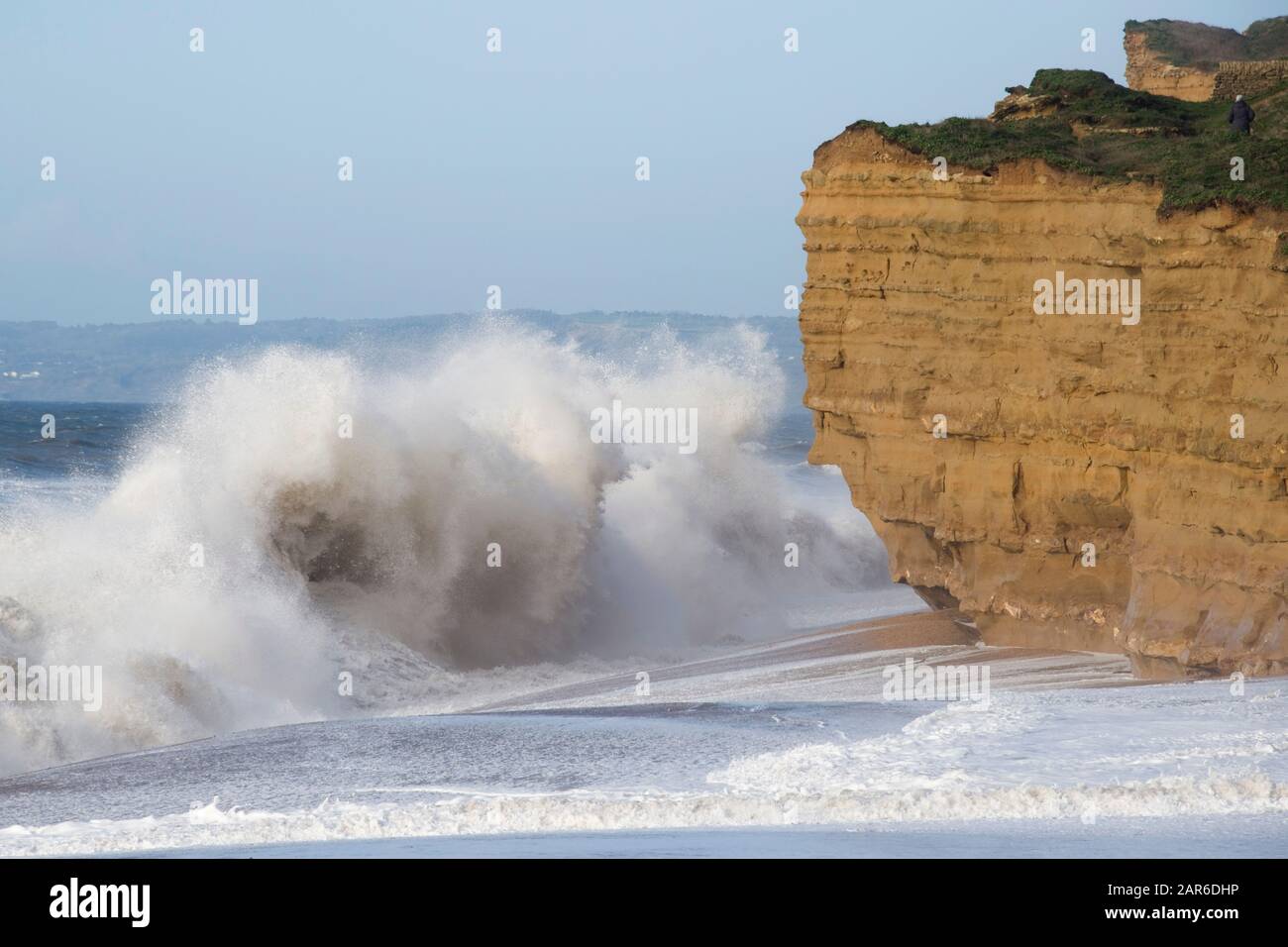 High white breakers from a Channel storm pounding and eroding the beach and sandstone cliffs on Hive Beach, near West Bay, Dorset, January Stock Photo