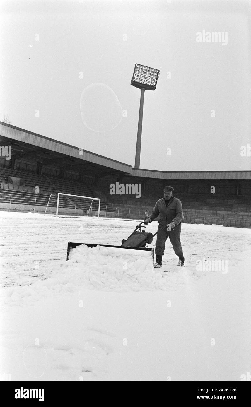 PSV stadium is made snow free for the football match against  Man with snow plow Date: 8 March 1971 Location: Eindhoven, Noord-Brabant Keywords: snow, sport, stadiums, football Institution name: Vorwarts Berlin Stock Photo