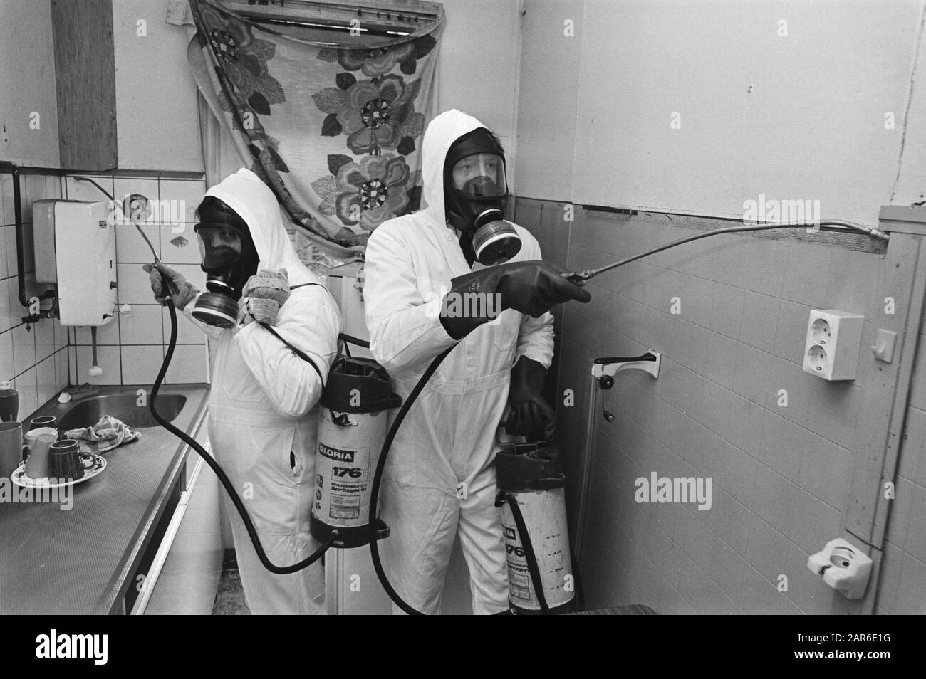 Men in protective clothing spray a kitchen to combat cockroaches Date
