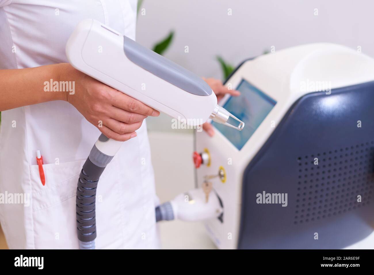 Doctor with apparatus for a laser procedure in a cosmetology clinic. Stock Photo