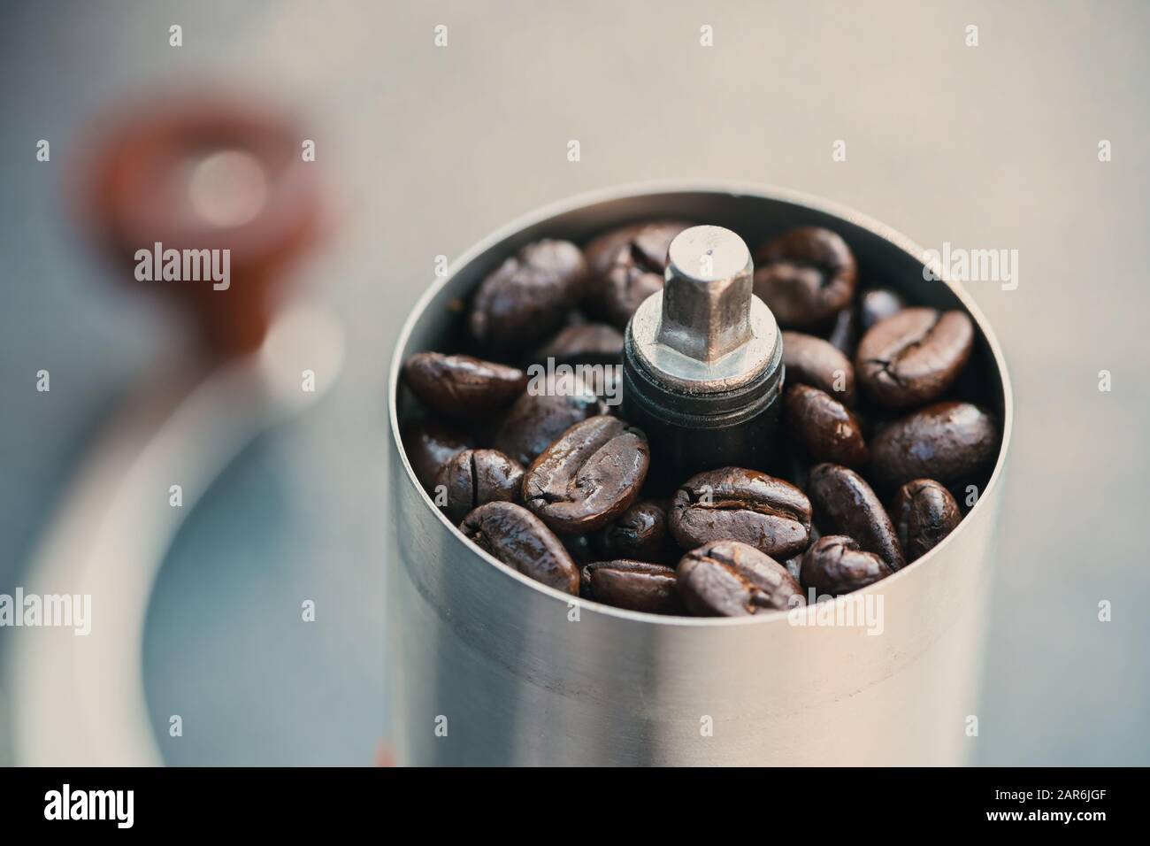 Coffee beans in a hand grinder, closeup roasted coffee beans into a manual coffee grinder Stock Photo