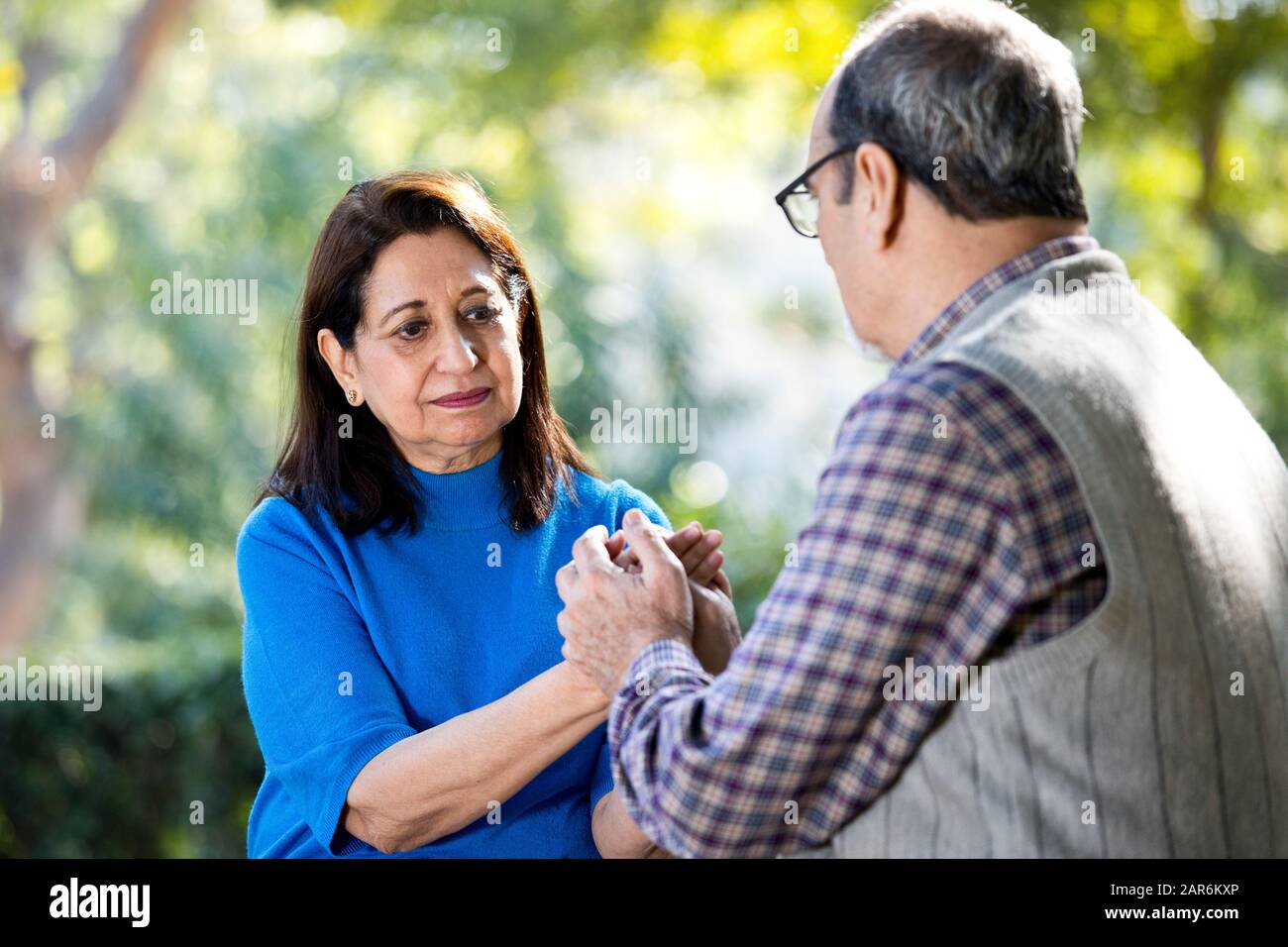 Happy senior couple holding hands at park Stock Photo - Alamy