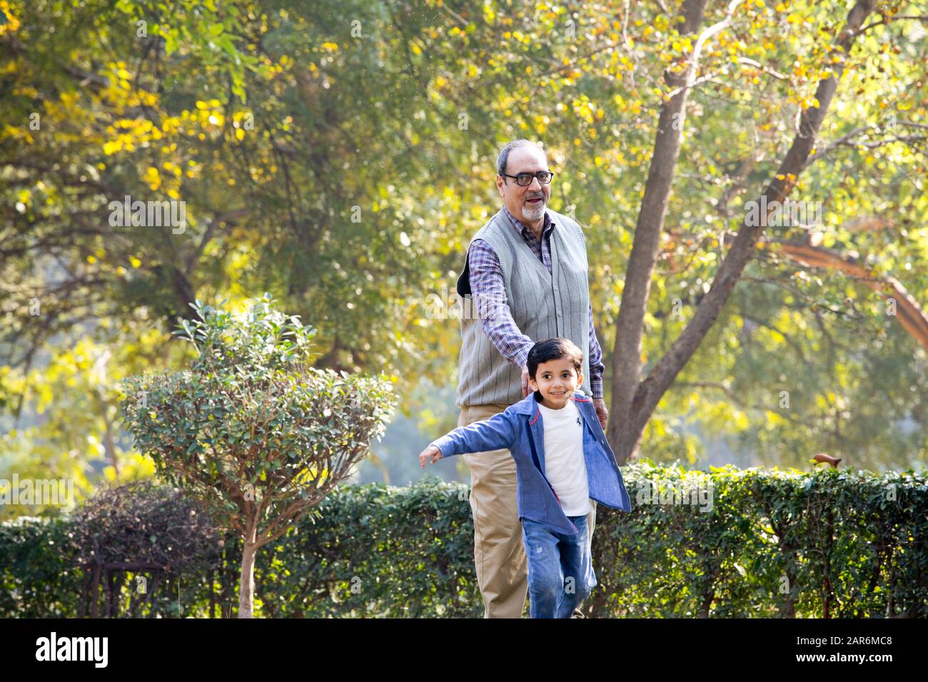 Grandfather playing with grandson at park Stock Photo