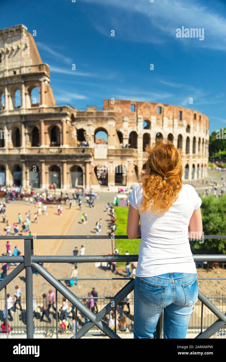 Young female tourist looks at the Colosseum in Rome, Italy Stock Photo