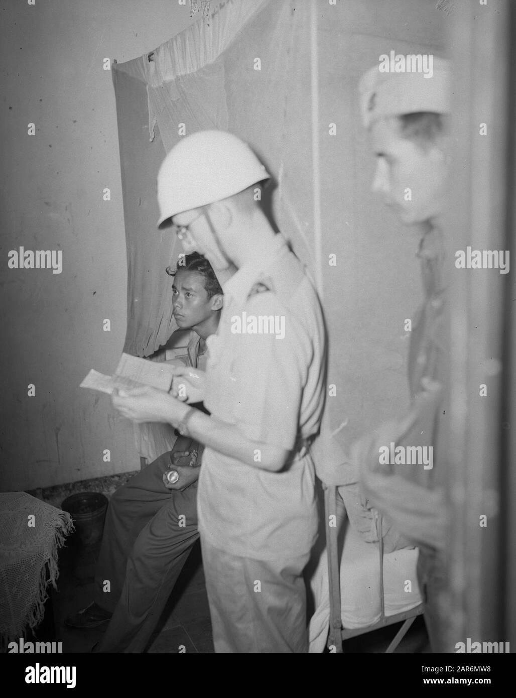 M.P. patrol Out of Bounds” neighborhoods  MP patrol in 'out of boundaries districts' [out of bounds = forbidden territory, a military term]. An MP officer checks paper Date: December 1946 Location: Batavia, Indonesia, Jakarta, Dutch East Indies Stock Photo