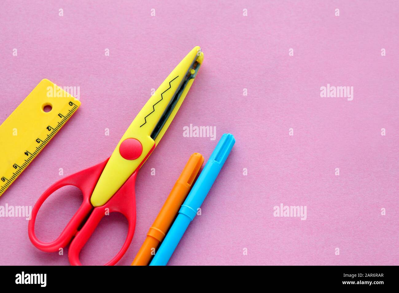 https://c8.alamy.com/comp/2AR6RAR/scissors-ruler-and-crayons-on-a-pink-background-creative-fashionable-minimalistic-school-or-office-workspace-with-yellow-supplies-for-handycraft-2AR6RAR.jpg