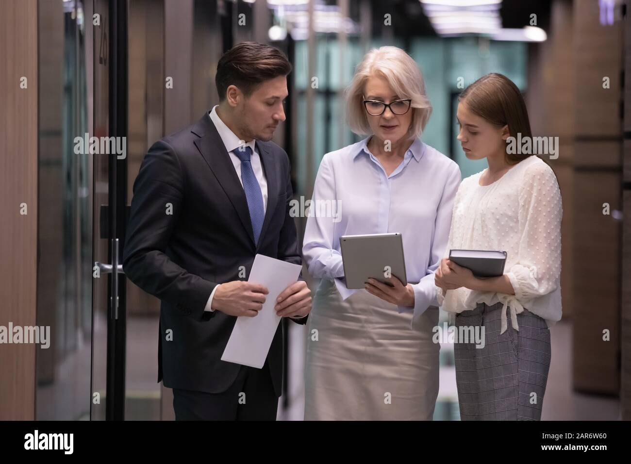 Concentrated middle aged female leader showing project results to colleagues. Stock Photo