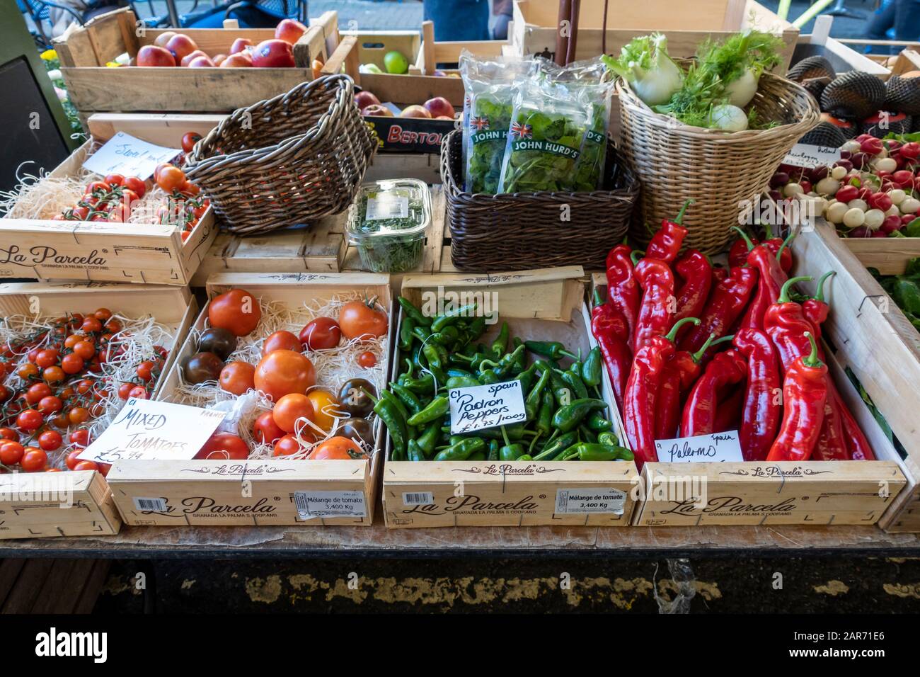 Close up of boxed vegetables for sale including Palermo Peppers, Padron Peppers and tomatoes at a grocer stall in Bristol, England, UK Stock Photo