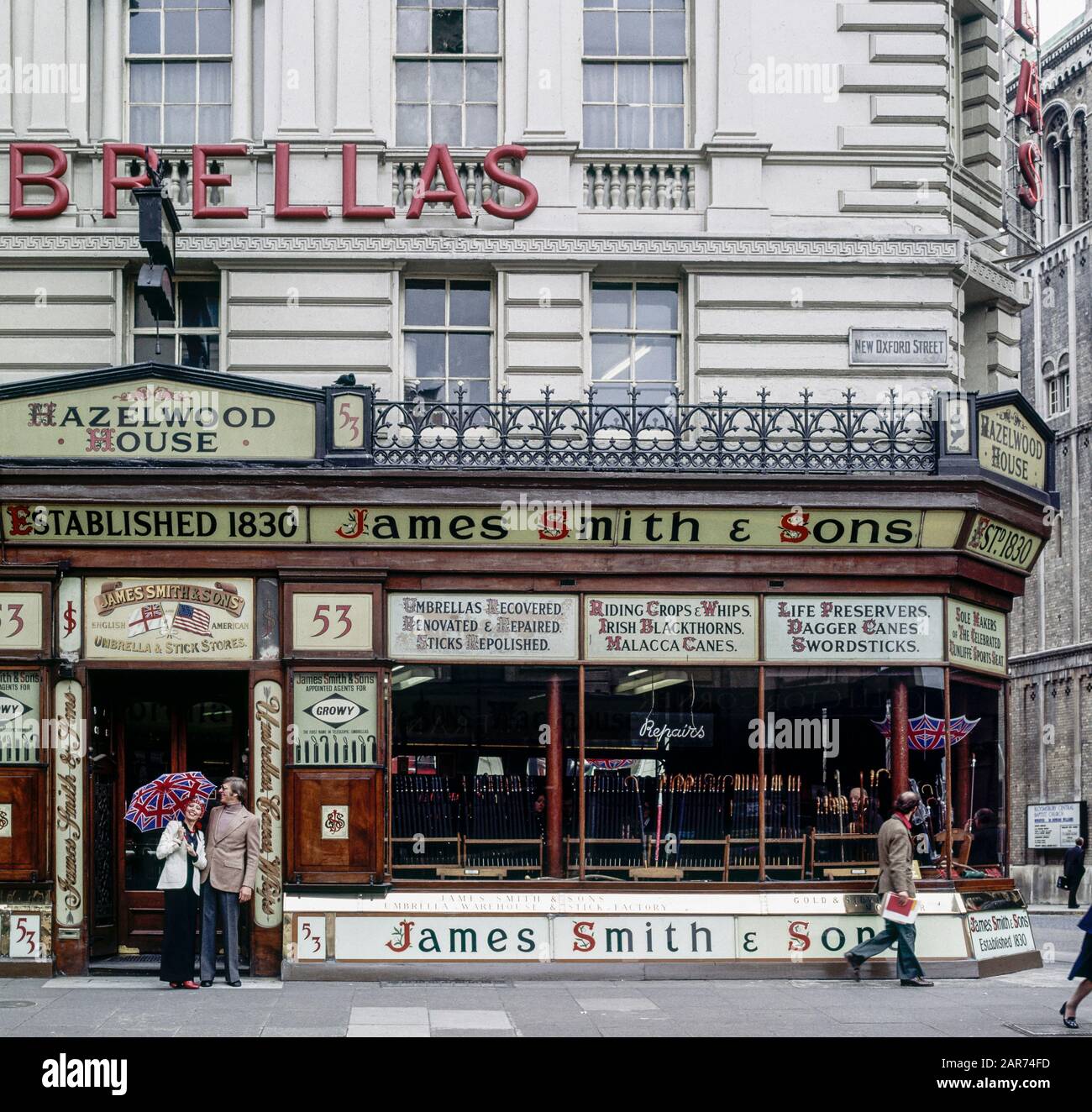 London 1970s, elegant couple shopping, James Smith & Sons umbrellas and sticks store, New Oxford street, England, UK, GB, Great Britain, Stock Photo