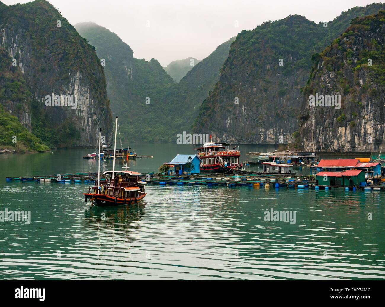 Fish farm with limestone rock cliffs, Lan Ha Bay, Vietnam, Asia Stock