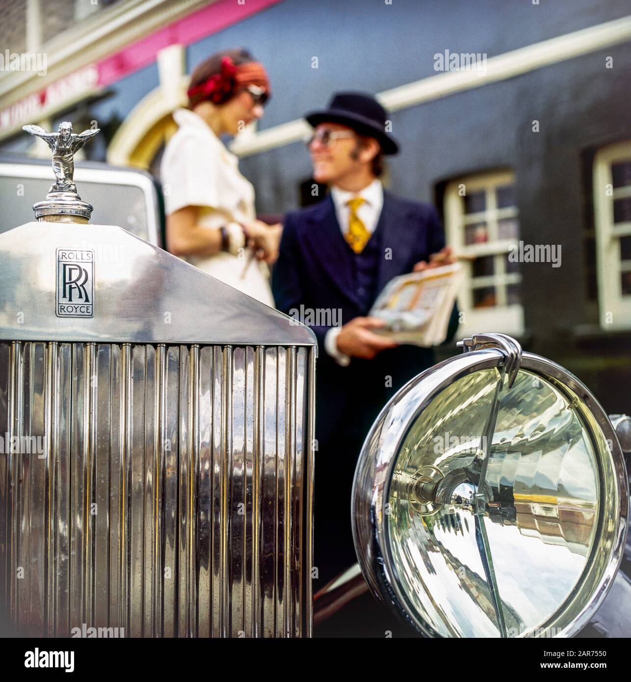 London 1970s, 1936 Rolls-Royce radiator grill, headlight, Spirit of Ecstasy statue, hood ornament, mascot, blurred elegant couple, England, UK, GB, Great Britain, Stock Photo