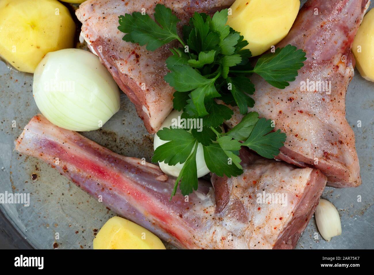 Lamb shank kebab on tray and potato onions around Stock Photo