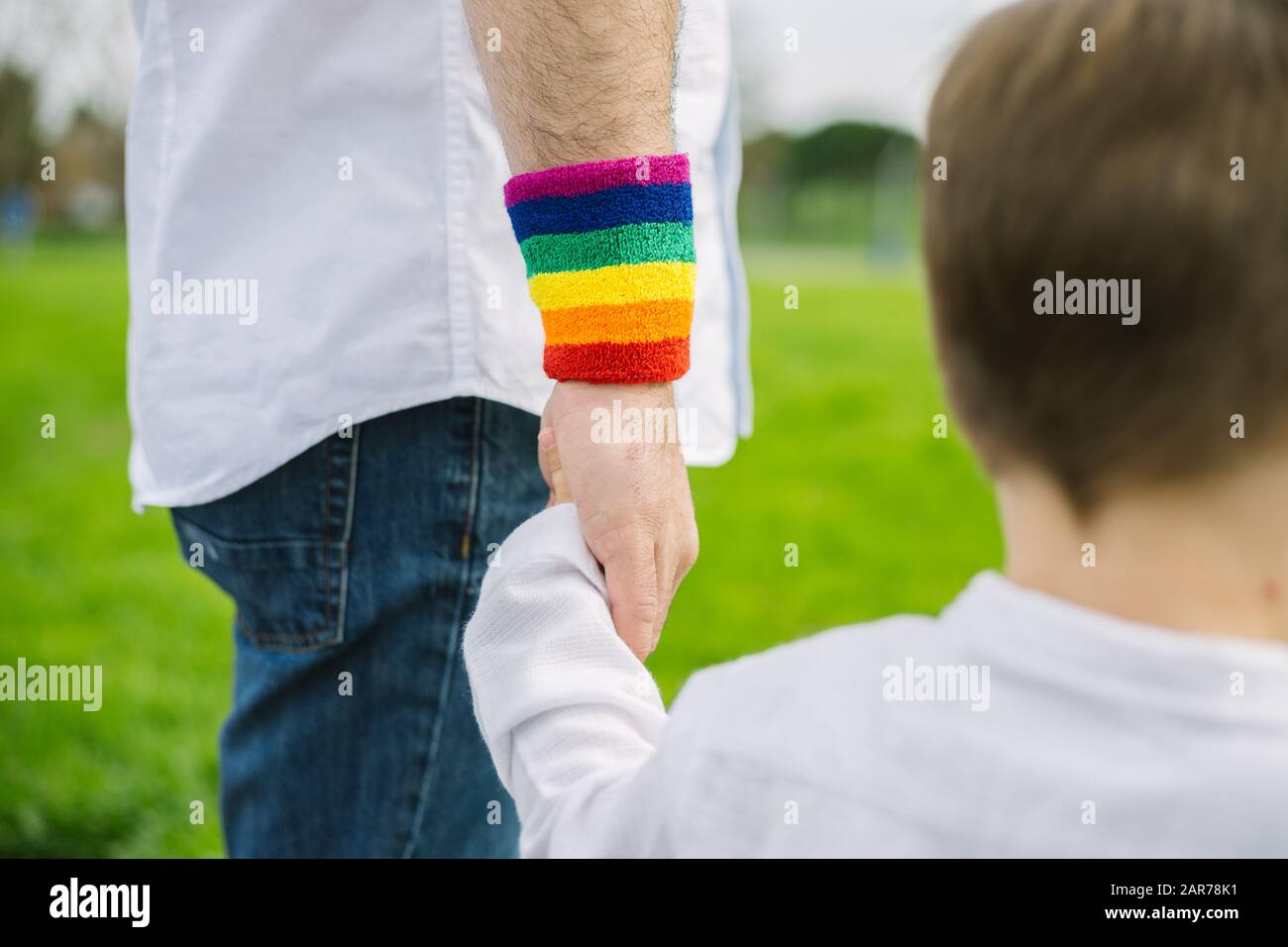 Gay father and his adopted son walking in the park. LGTB and Stock Photo