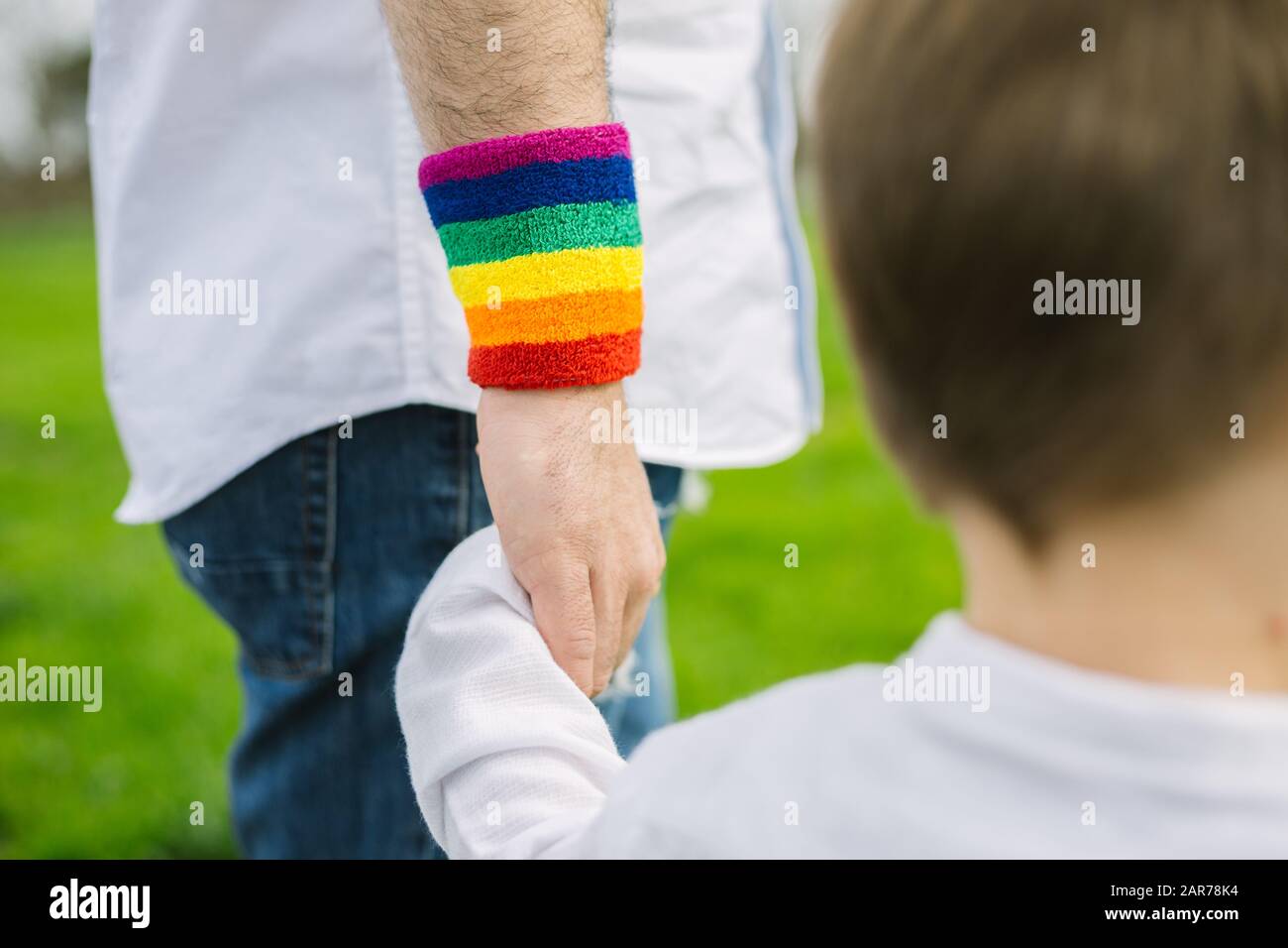Young man and his adopted son walking in the park. LGTB and Stock Photo