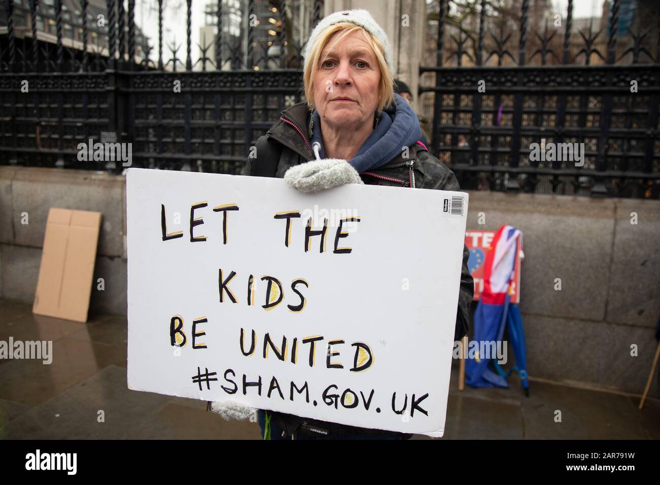 Anti Brexit protester with a placard reading let the kids be united. #sham.gov.uk alluding to a sham government in Westminster outside Parliament on 22nd January 2020 in London, England, United Kingdom. With a majority Conservative government in power and Brexit day at the end of January looming, the role of these protesters is now to demonstrate in the hope of the softest Brexit deal possible. Stock Photo