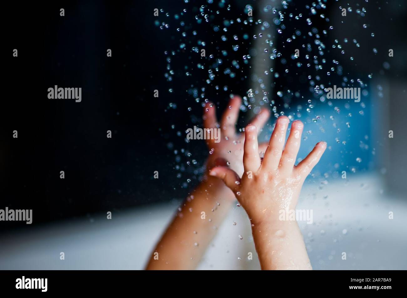 hands of a small child reach for water close-up Stock Photo