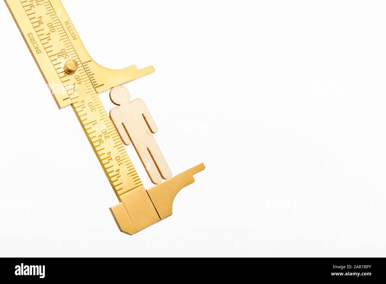 Macro small laser-cut wooden figure & brass calipers against off-white BG. Measuring personal performance indicators, demographics, productivity, Stock Photo