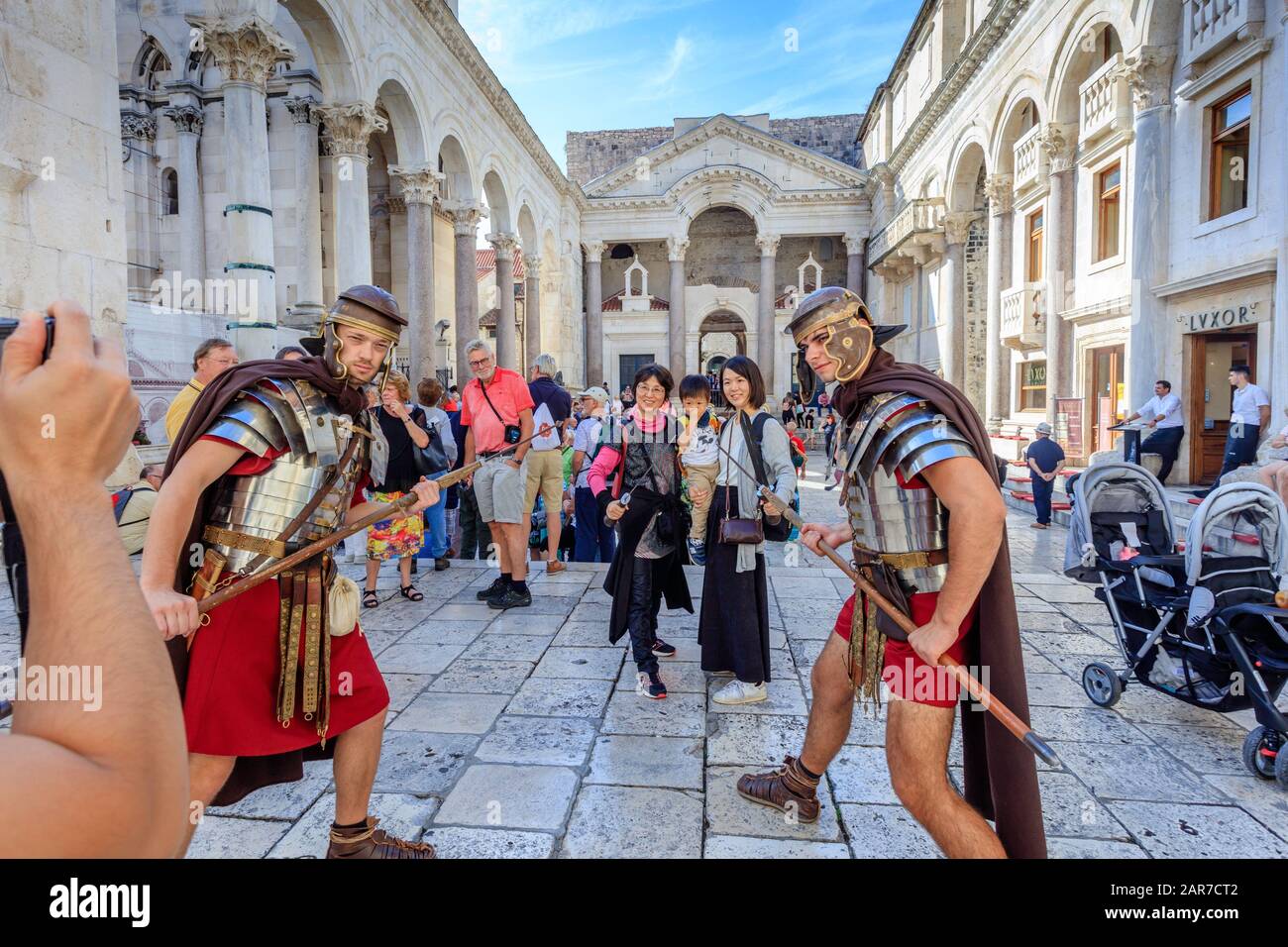 Two actors dressed as Roman gladiators pose for a picture with tourists in the Diocletian Palace. Split. Croatia. Stock Photo