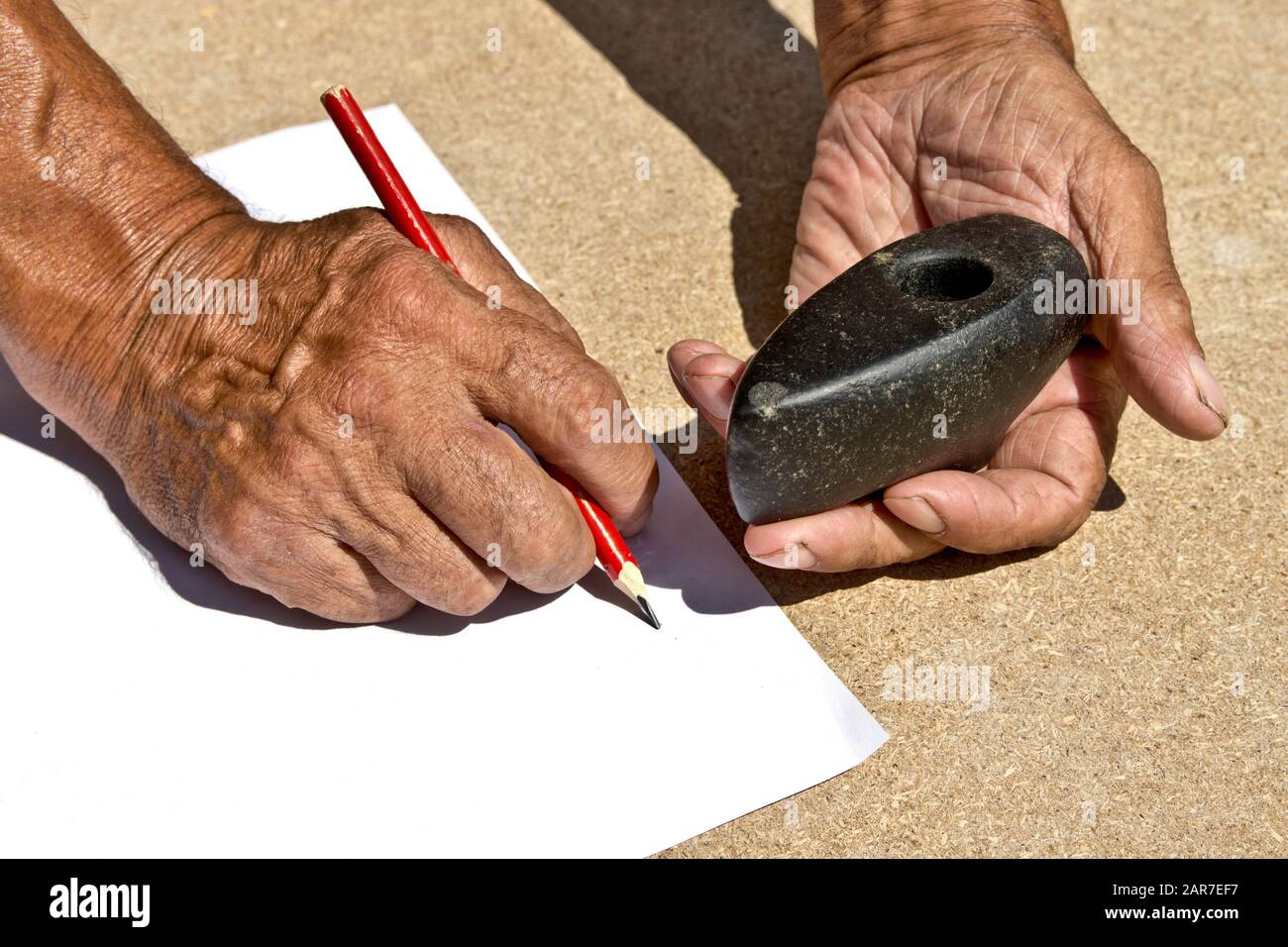 An old stone Hammer an elder man holds in his hands. Archaeology. Study