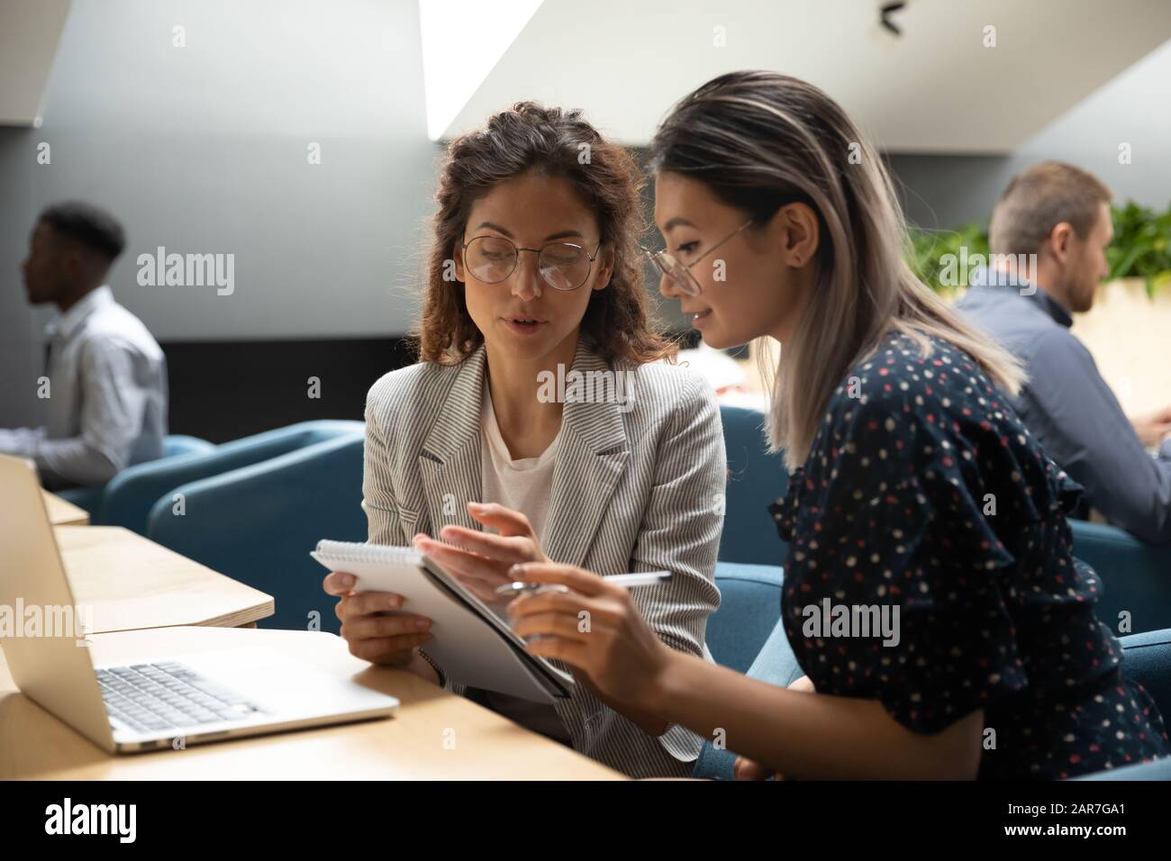 Focused millennial women discuss business plan in office Stock Photo