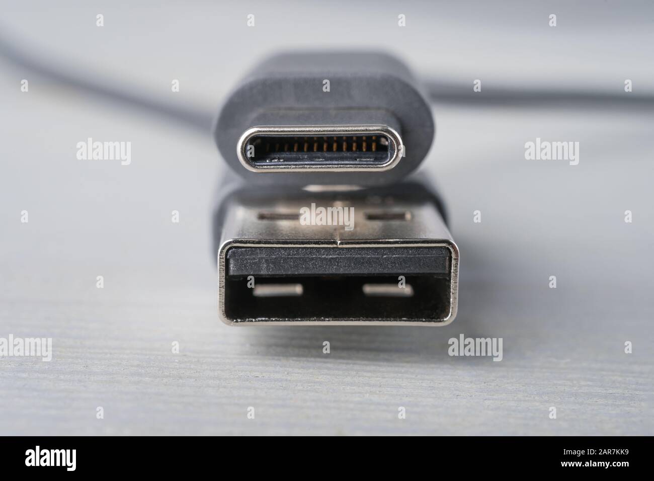 USB Type C and A connector with a grey cable on a wooden background. Closeup with shallow depth of field. Stock Photo