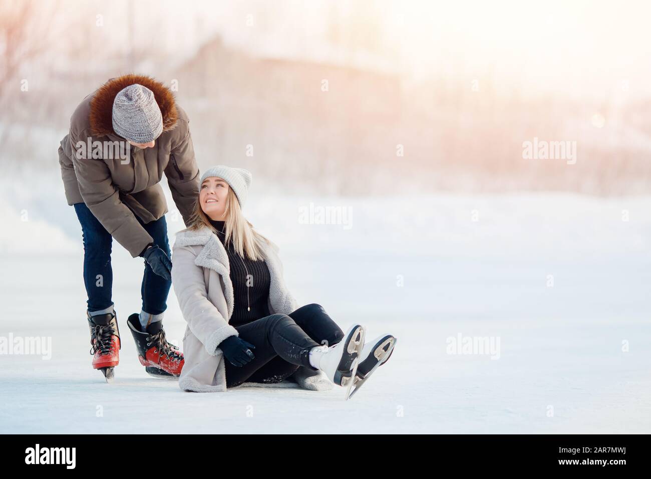 Girl shows guy where she has pain after fall injury on ice skating rink