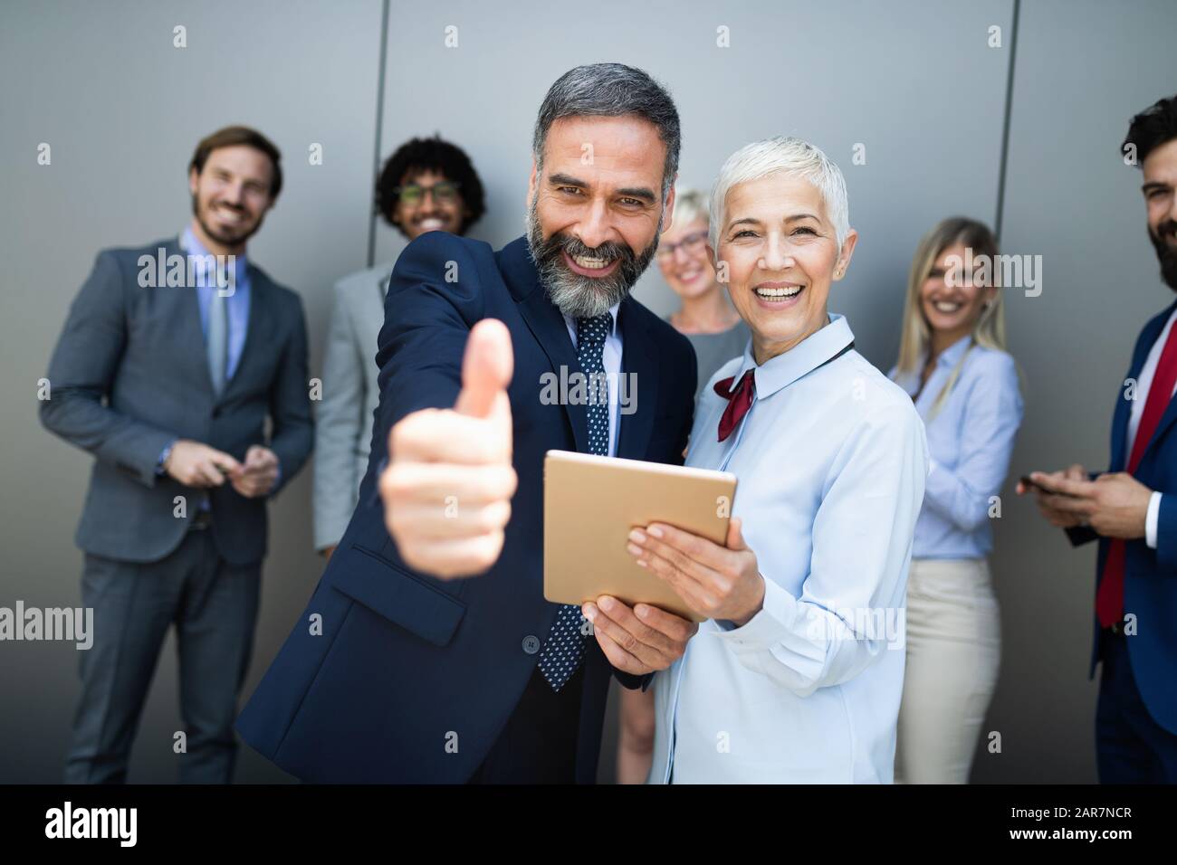 Portrait of thumb up smiling business people Stock Photo - Alamy