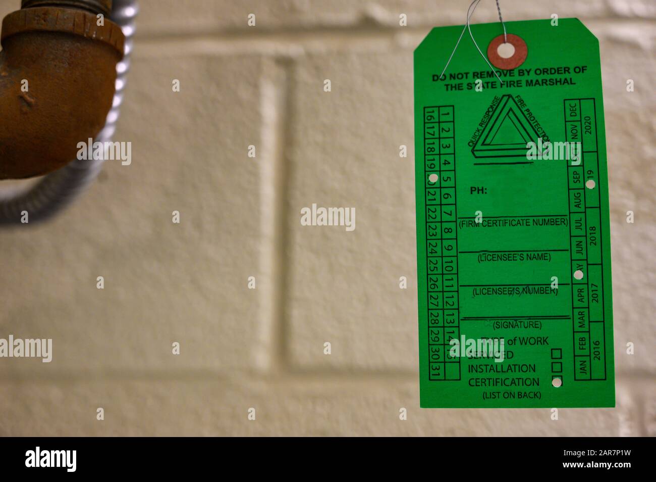 Blank safety equipment inspection tag hanging on pipes Stock Photo Alamy