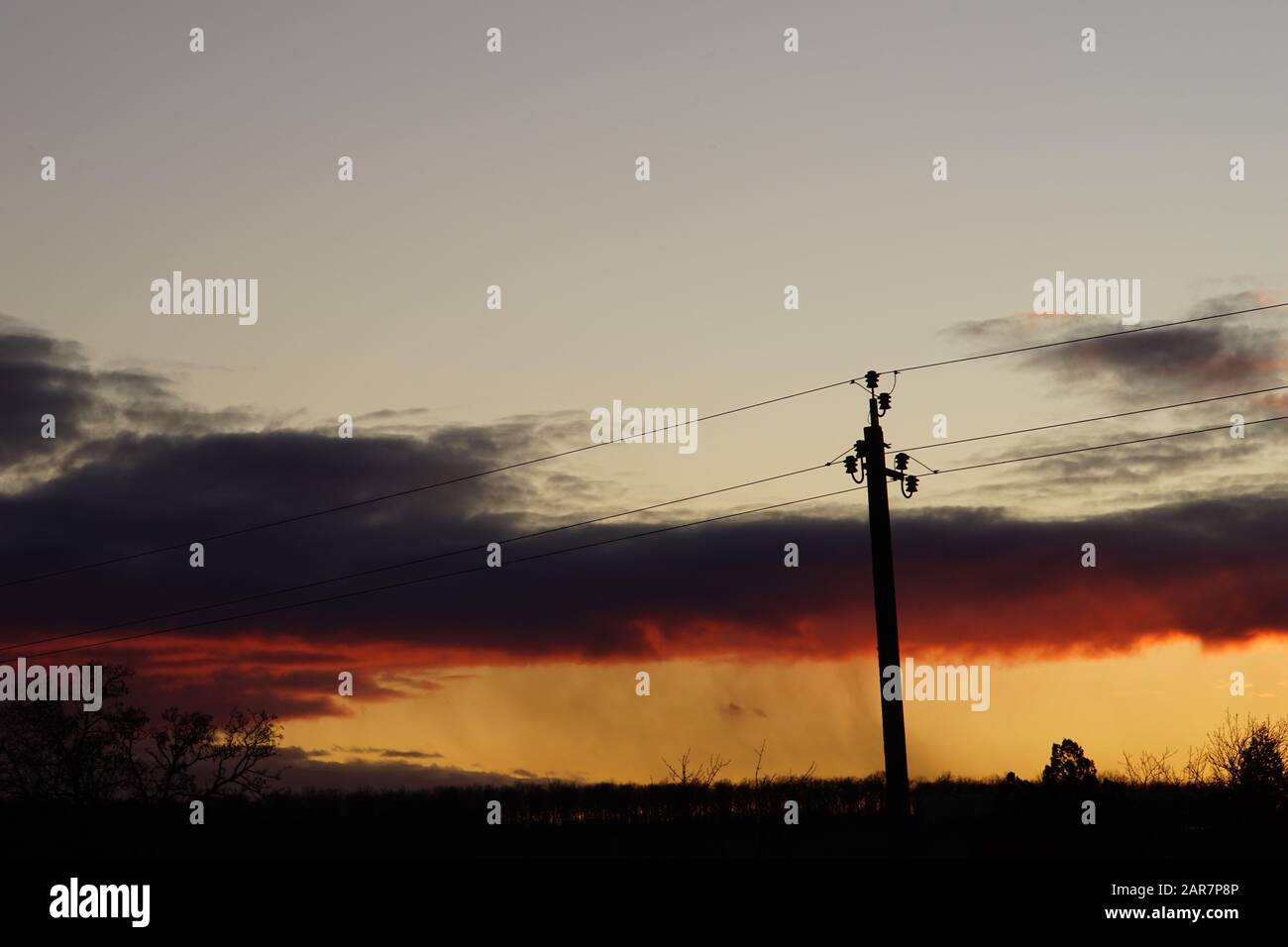 Silhouette high voltage electric tower on sunset sky background. Stock Photo