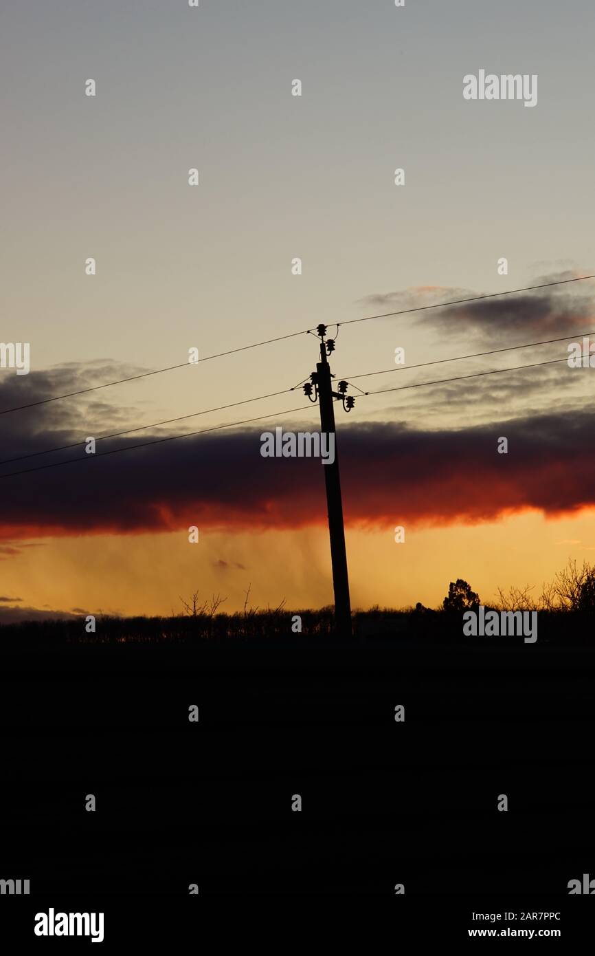 Silhouette high voltage electric tower in sunset sky Stock Photo - Alamy