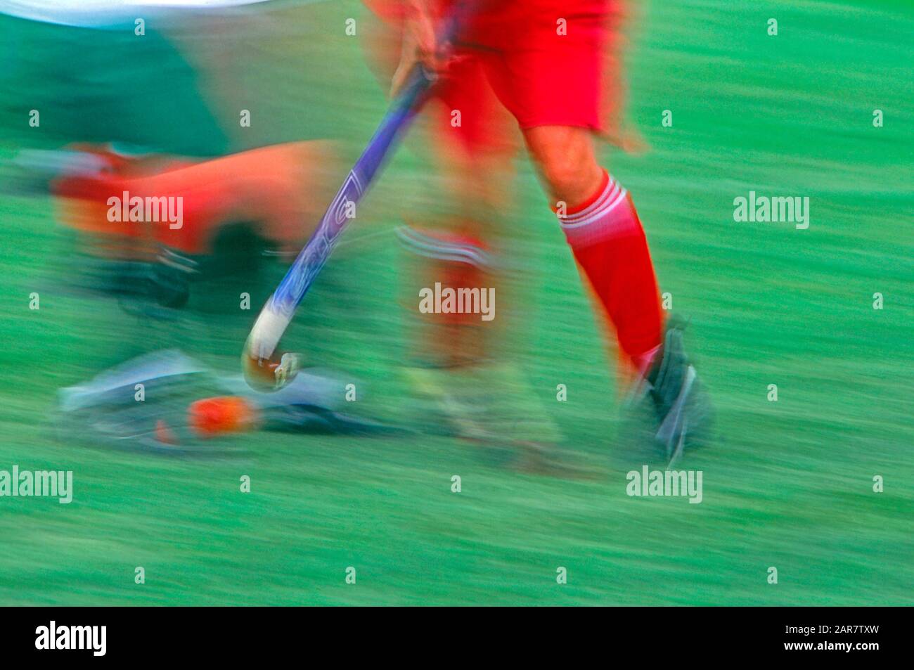 Women's field hockey played on a natural grass field. Blurred motion photograph Stock Photo