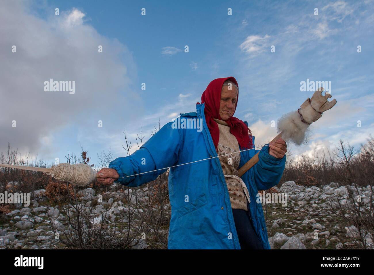 A Bosnian  woman spins while keeping an eye on her cattle in the mountains of eastern Herzegovina, near the southernmost Bosnia-Herzegovina's town Stock Photo