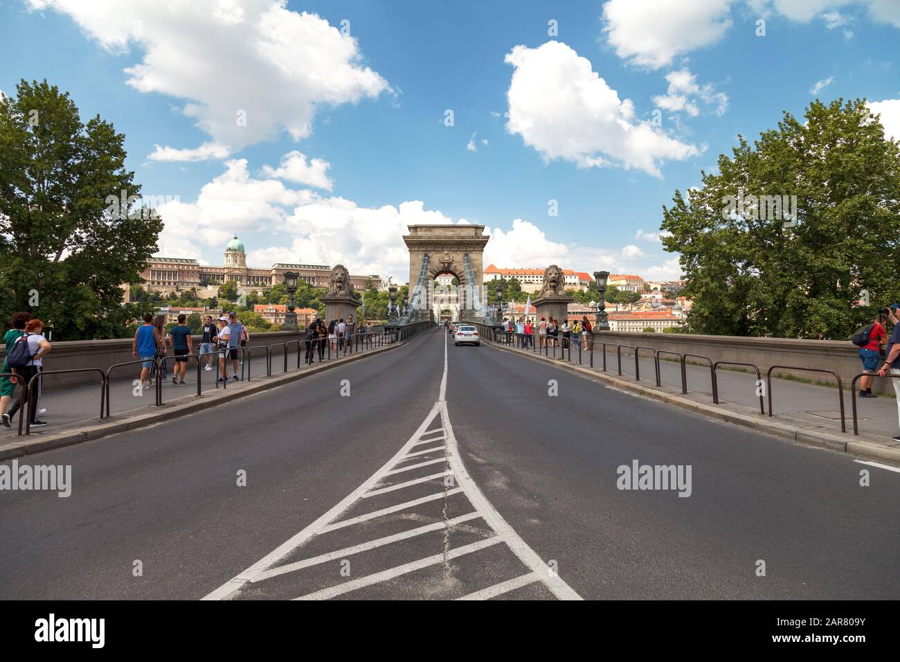 Cars cross the Secheni Chain Bridge in Budapest across the Danube River. Many tourists admire