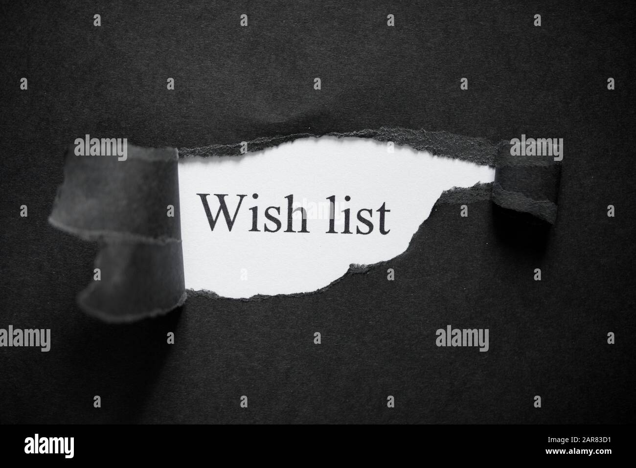 Word wish list printed on a white background with black torn paper. New year Stock Photo