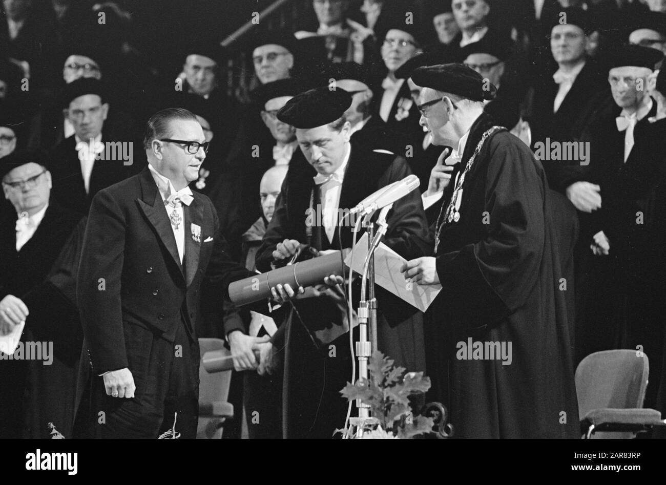 Honorary doctorates of the Vrije Universiteit in the Concertgebouw in Amsterdam  Prof. mr. De Gaay Fortman while he gave to His Excellency Mr. E. Jonckheer, Prime Minister of the Dutch Antilles, the doctorate for the honorary doctorate in law awards Date: 20 October 1965 Location: Amsterdam, Noord-Holland Keywords: honorary doctorates, ministers-presidents, ceremonies Personal name: De Gaay Fortman, W.F., Jonckheer, E. Stock Photo