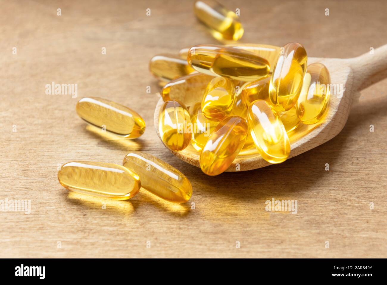 Cod liver oil omega 3 gel capsules on a spoon on wooden background. Fish oil  vitamins Stock Photo - Alamy
