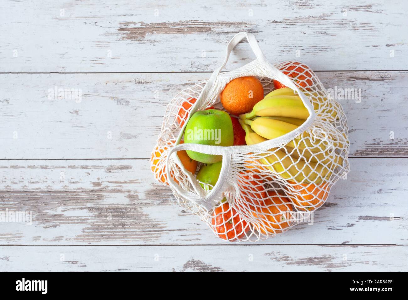 Cotton mesh bag for grocery with fruits and vegetables. Zero waste, no plastic shopping. Sustainable lifestyle concept. Recycling. Stock Photo