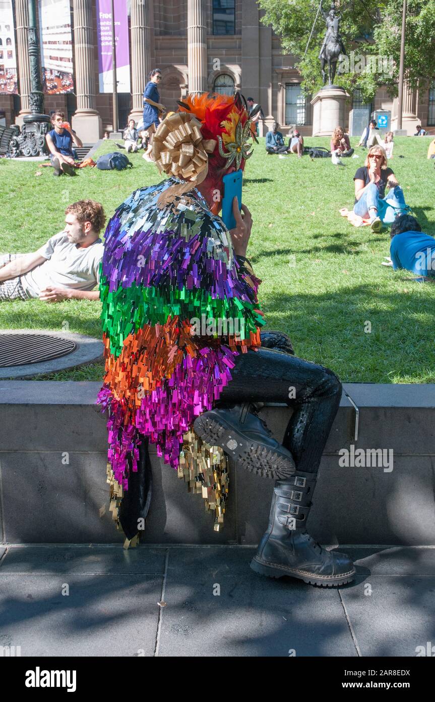 Colourfully-costumed artiste makes a call outside the State Library of Victoria on Swanston Street, Melbourne, Australia Stock Photo