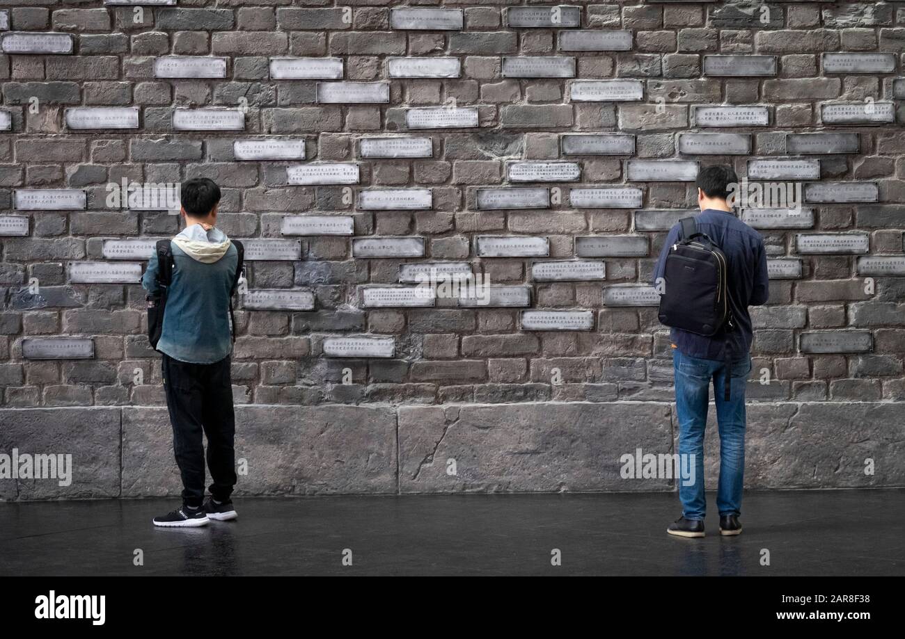 NANJING / CHINA - NOV 03 2019: The unspecific man looking at  name of victims in the memorialize 300,000 people. It is to memorialize 300,000 people k Stock Photo