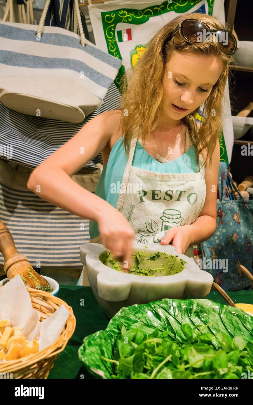 Blond teenage girl is  making homemade pesto at a cooking class where it was invented,  Ligurian Riviera, Levanto, Italy Stock Photo