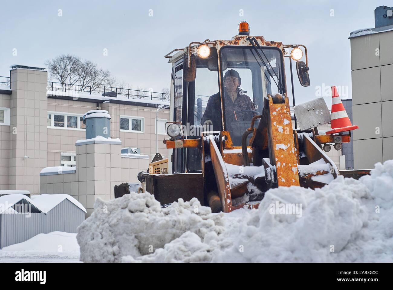 Perm, Russia - Jauary 26, 2020: loader removing snowdrift in city courtyard Stock Photo