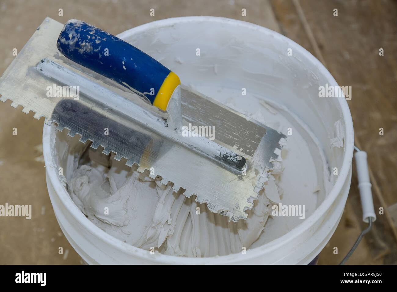 Trowel mortar tIling a closeup with new cement trowel ceramic tiles
