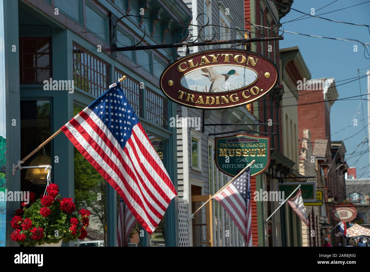 Clayton, NY, USA - July, 2019: Building Shop Facade on James St during summer season, American flags and Iron wooden store signboards Stock Photo