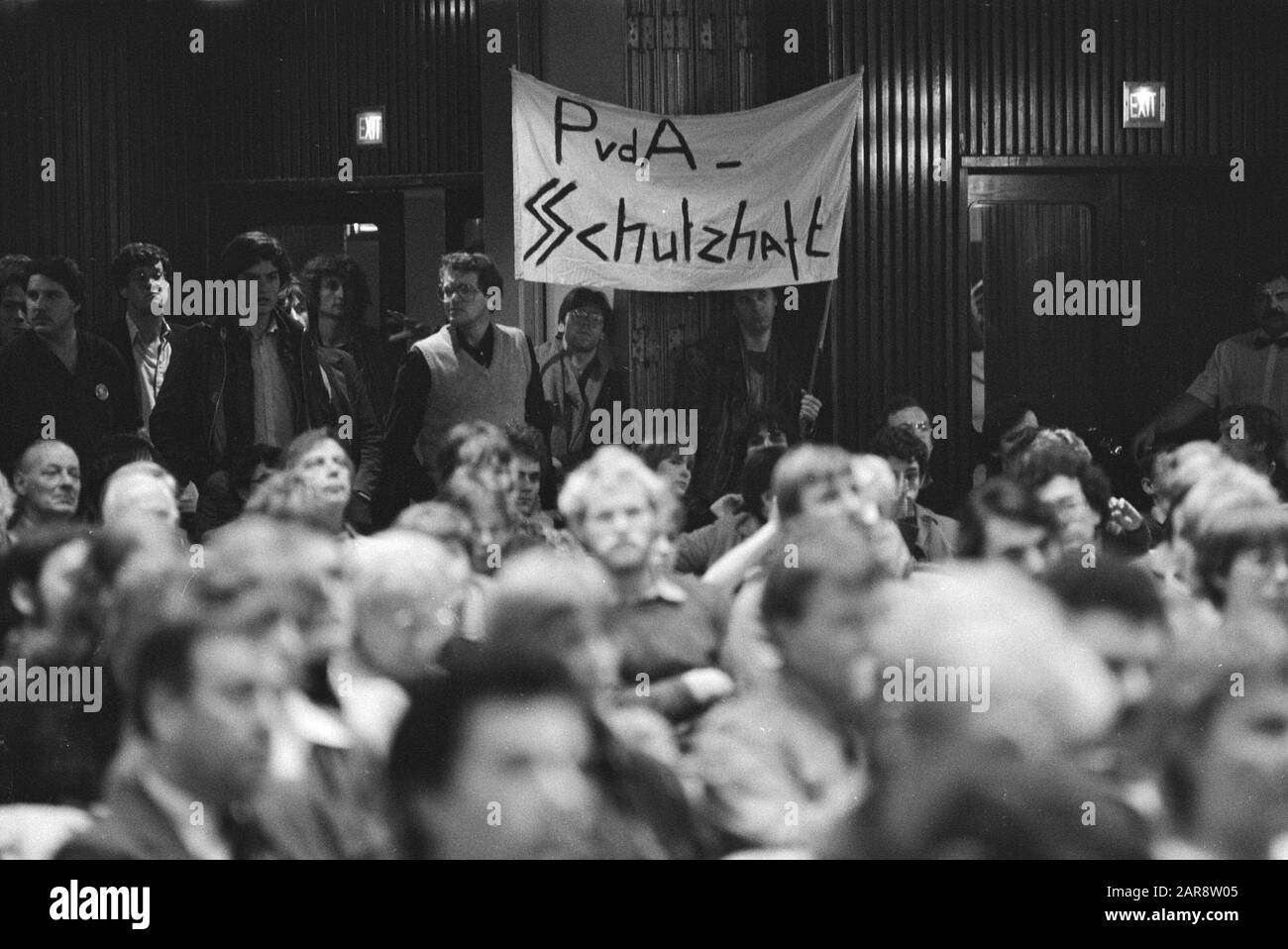 Public meeting of the PVDA in Krasnapolsky in Amsterdam about riots around the evacuation of the building Lucky Luijk  hearers with banner with the text PVDA - Schutzhaft (capture for the State security) Date: 19 October 1982 Location: Amsterdam, Noord-Holland Keywords: meetings, squatting, banners, hearers Stock Photo