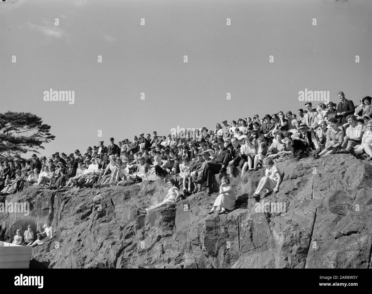 Scotland - The Highlands  Spectators at the Highland Games, a nineteenth century continuation of traditional clan games from the Highlands of Scotland Date: 1934 Location: Great Britain Keywords: public, rocks Stock Photo