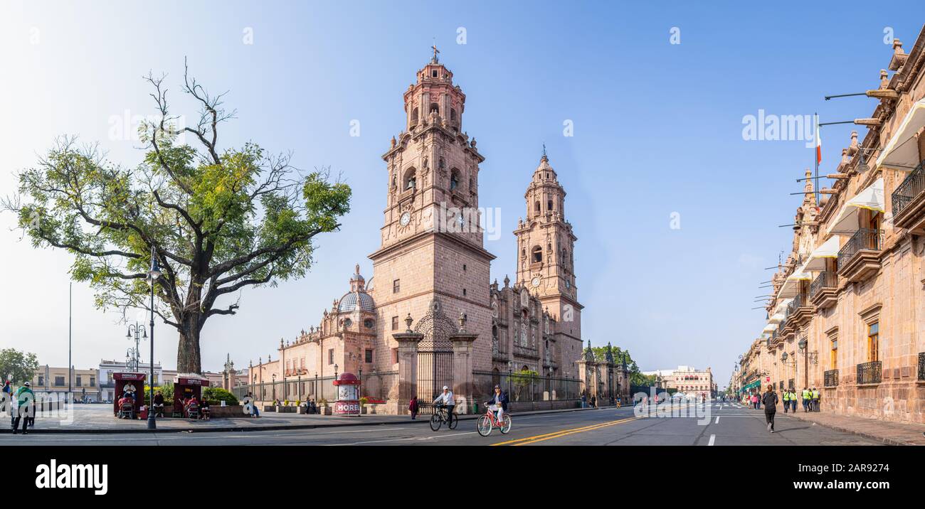 Morelia, Michoacan, Mexico - November 24, 2019: The Morelia Cathedral as seen from Mexico 15, and the Government Palace, people running and riding bik Stock Photo