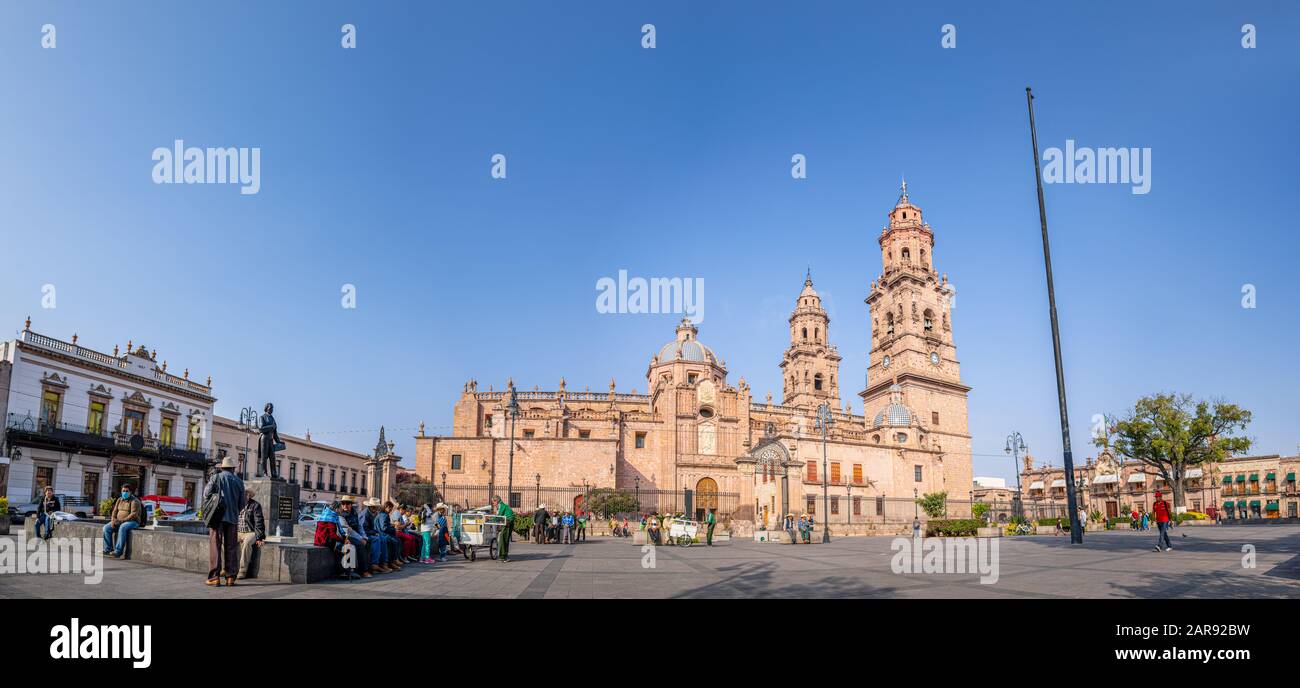 Morelia, Michoacan, Mexico - November 24, 2019: People enjoying the morning at the Menchor Ocampo plaza, with the Morelia Cathedral in the Background Stock Photo