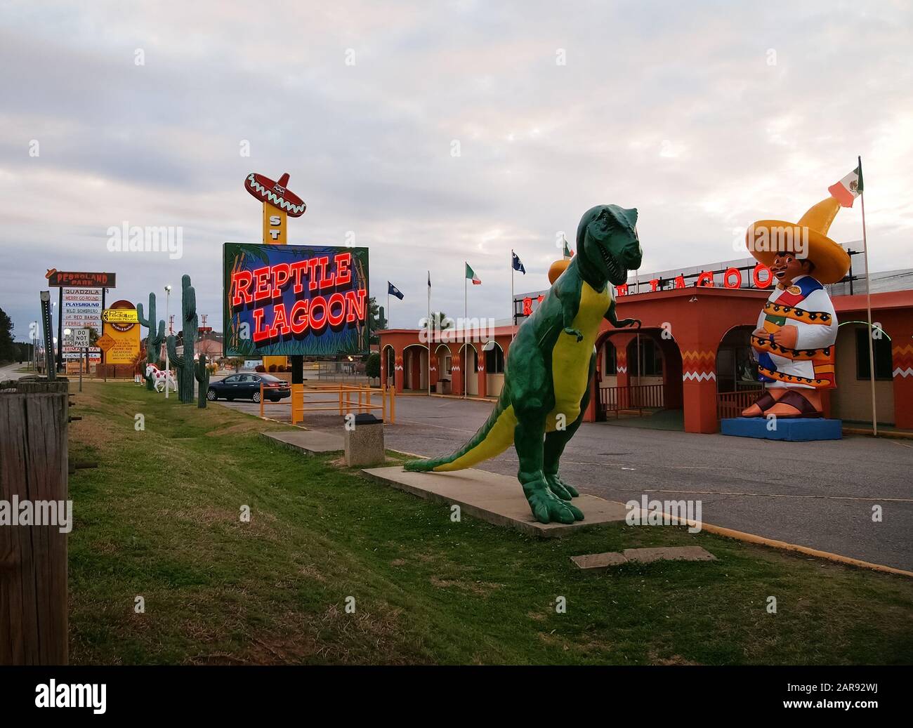DILLON, SOUTH CAROLINA - FEBRUARY 18, 2018 : A large green fiberglass dinoursaur sculpture stands outside the Reptile Lagoon, a roadside attraction ju Stock Photo
